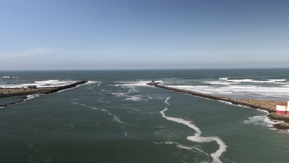 Flying back revealing the Coquille River Lighthouse and opening to the Pacific Ocean, aerial alt