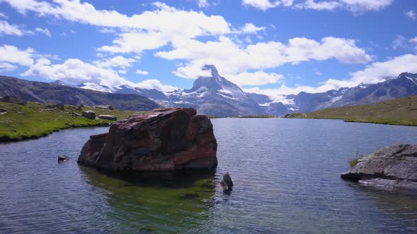 Aerial travel drone view of Zermatt at the Stellisee Lake, Mount Matterhorn, Switzerland. alt