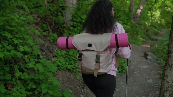 Woman Traveler with Trekking Poles in the Wood alt