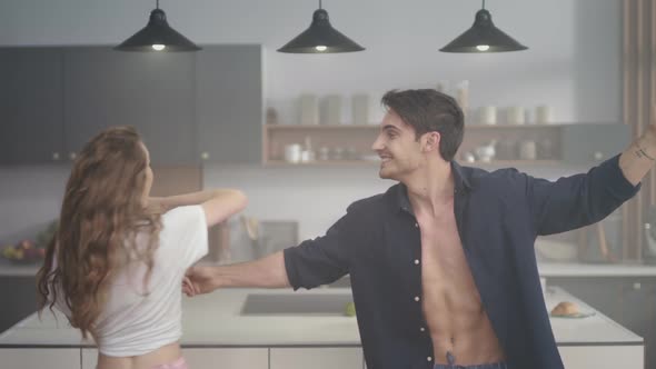 Excited Couple Having Fun at Domestic Kitchen, Attractive Man Holding Woman Hand alt