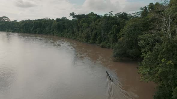 Aerial View Of Travelling Canoe Across A River In The Green Jungle Of Ecuador. Drone Shot alt
