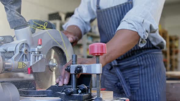 Carpenter cutting wooden plank with electric saw 4k alt