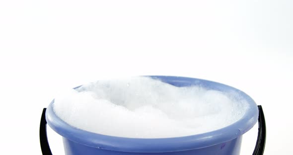Cleaning sponge falling in to bucket of soap suds alt