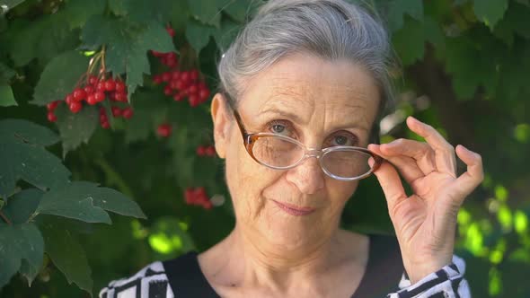 Beautiful Old Grandmother with Grey Hair and Face with Wrinkles Wearing Eyeglasses is Grimacing and alt