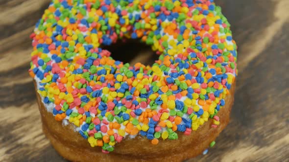 Top View of Colorful Donut Ring on Wooden Brown Background
