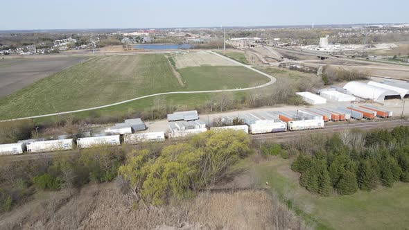 View over industrial park, open field, retention pond, railroad tracks and city in the distance.