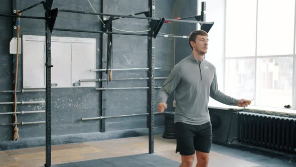 Fit Sportsman Skipping with Jump Rope in Gym Concentrated on Cardio Exercise alt