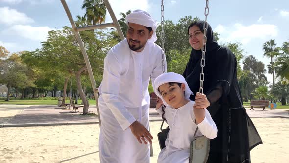 Emirati Family spending during the day. Arab Father with his Middle Eastern Wife and Son wearing Kan alt