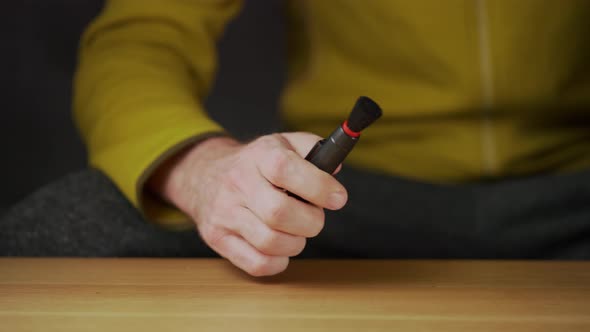 A caucasian man cleaning the camera lens, removing dust and showing thumbs up gesture alt