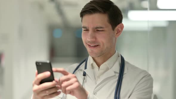 Portrait of Male Doctor Using Smartphone in Office alt