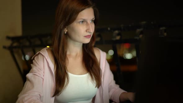 Young Woman Works with a Laptop Night Time alt