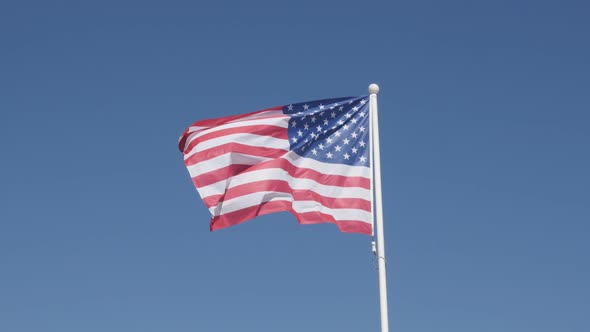 United States of America flag fabric against blue sky 4K 2160p 30fps UltraHD footage - Silky materia