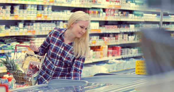 Woman Opening Glass Door of the Fridge and Taking Frozen Food at Supermarket alt