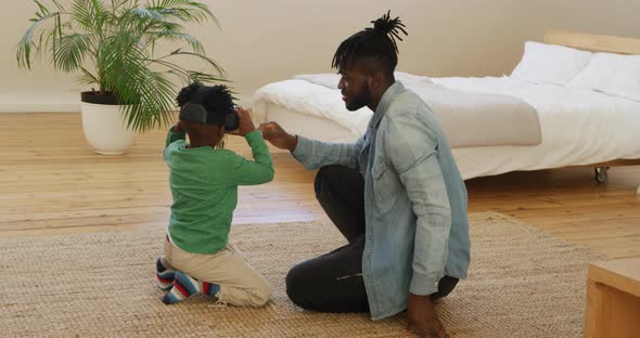 Father and son at home using VR alt