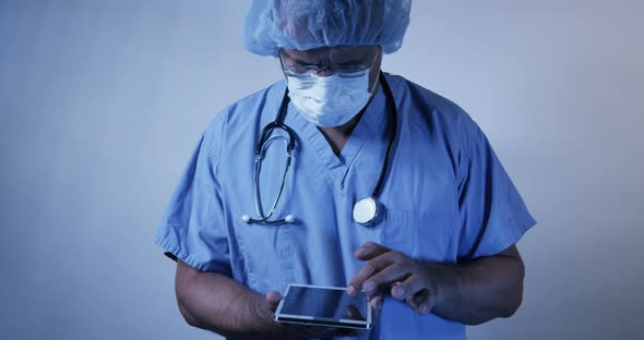 Doctor Wearing Surgical Scrubs Using Wireless Tablet 21