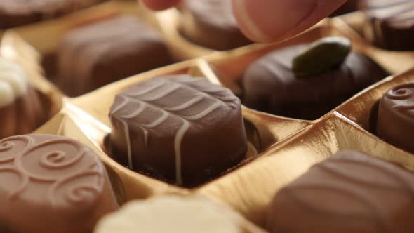 Picking one from chocolate box different type candies 4K 2160p 30fps UltraHD footage - Assorted  swe alt