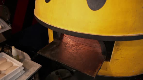 Overhead View of Warm Glow From a Yellow Pizza Oven in the Restaurant alt