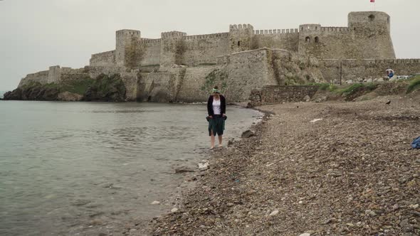 a-woman-hardly-trying-to-walk-on-the-pebbles-on-the-rocky-seaside