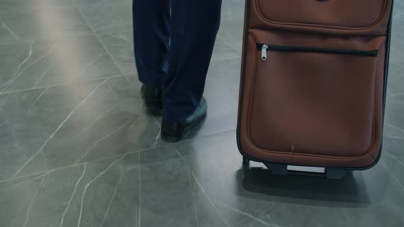 Slow Motion Tiltup of Arab Man Walking To Hotel Reception Desk Talking To Manager Getting Key Card alt