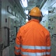 Electrician Walks Down Corridor Between Electrical Panels - VideoHive Item for Sale