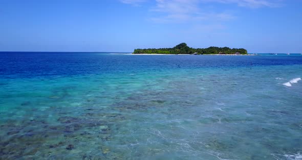 Natural birds eye island view of a white paradise beach and blue ocean background in vibrant 4K alt