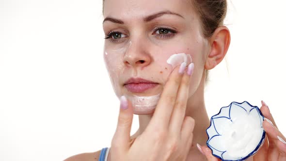 Woman Applying Mask Cream on Face