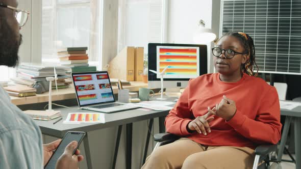 Woman in Wheelchair Discussing Renewable Energy with Colleague alt