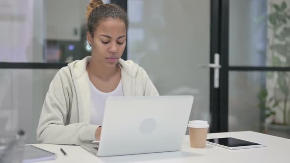 African Woman Shaking Head As No Sign While Using Laptop in Office alt