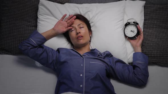 Woman with Insomnia Holding Clock