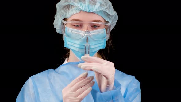 Professional Female Doctor Holds a Syringe with a Vaccine on a Black Background alt