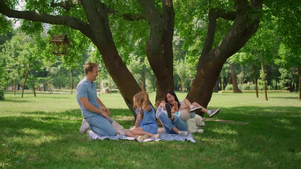 Cheerful Parents Tickling Kids on Picnic alt