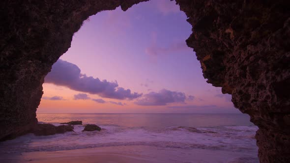 View From the Cave a Sandy Beach Along the Ocean at Sunset alt