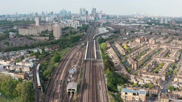 Stationary drone shot of busy British rail train tracks towards London city centre alt