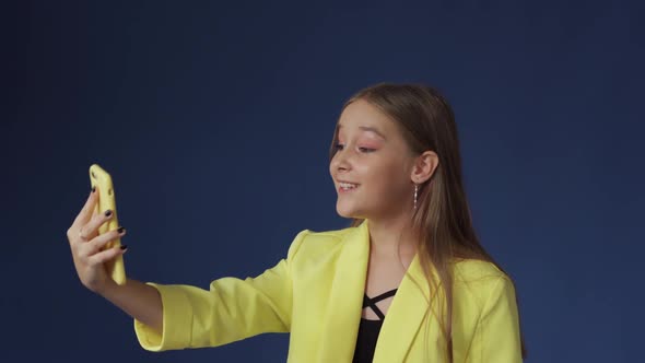 Teenage Girl in Sassy Clothes Taking Selfies on Her Phone alt