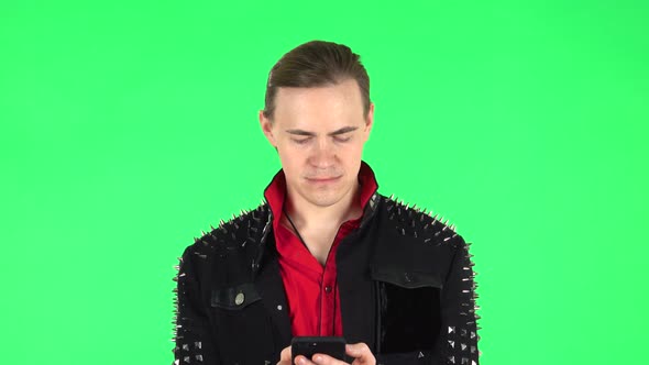 Guy Texting on His Phone. Green Screen alt