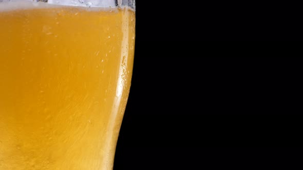 Light Beer Pouring in Glass with Bubbles and Foam