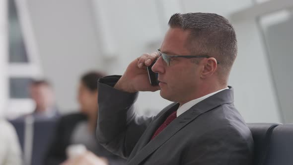 Businessman talking on cell phone at airport