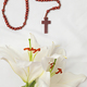 A symbolic Christian composition with christian cross lies beside a fresh white lily - PhotoDune Item for Sale