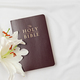 A symbolic Christian composition with Holy Bible lies beside a fresh white lily - PhotoDune Item for Sale