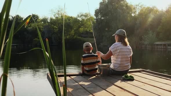 Young Woman Fishing with Her Little Son alt