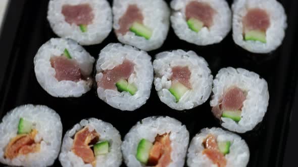 Close up sushi rolls otating. Japanese food with avocado, salmon, tuna. alt