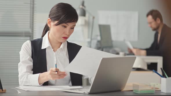 Female Asian Engineer Doing Paperwork in Office alt