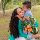 Mother&#39;s Day Affection: Son Giving a Kiss and Flowers to His Happy Mom - PhotoDune Item for Sale