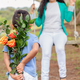Young Boy Surprising Mother with Bouquet of Orange Roses Outdoors - PhotoDune Item for Sale