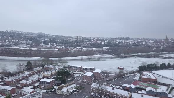 Panning drone shot of snowy Exeter over the River Exe alt