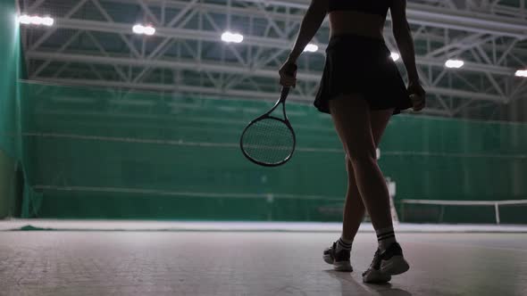 Sporty Woman is Walking on Tennis Court Indoors Throwing Ball and Catching Rear View Professional alt