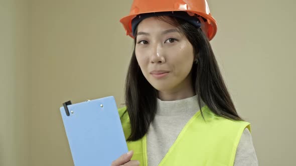 Asian Woman Builder in Protective Clothing