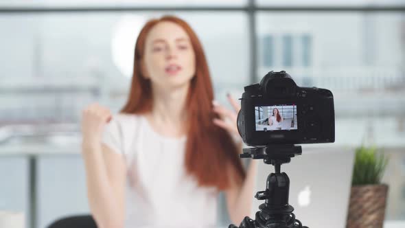Young Redhead Female Blogger on Camera Screen