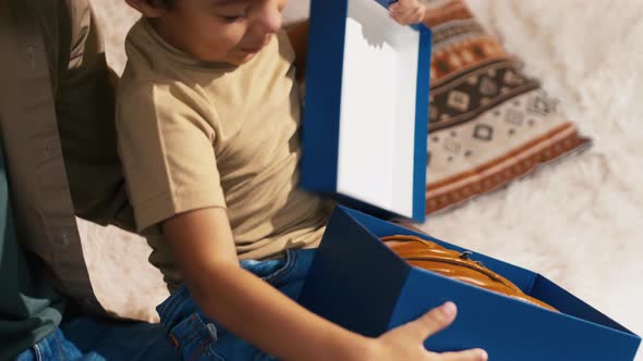 Boy opening present box with baseball glove