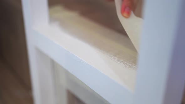 Crop unrecognizable woman sticking duct tape on steps at home alt